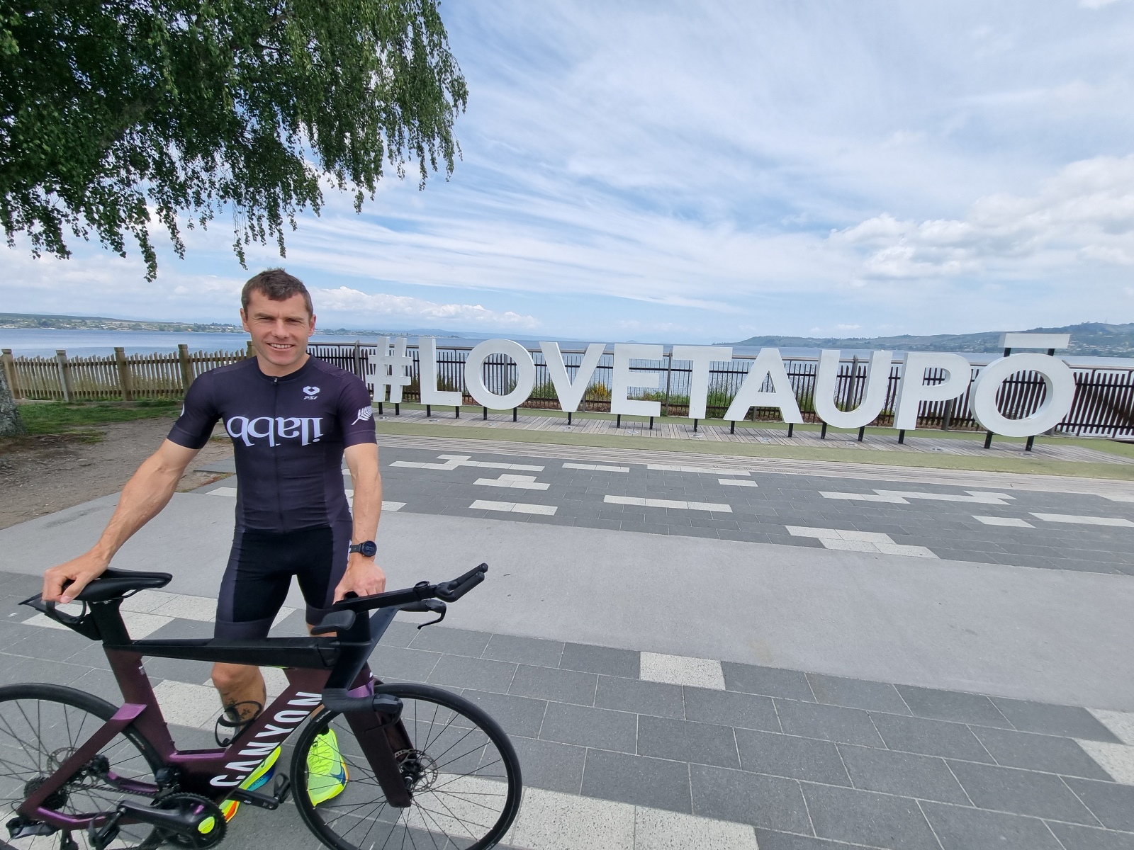 Taupō athlete Nick Saunders in front of the #LoveTaupo sign.  